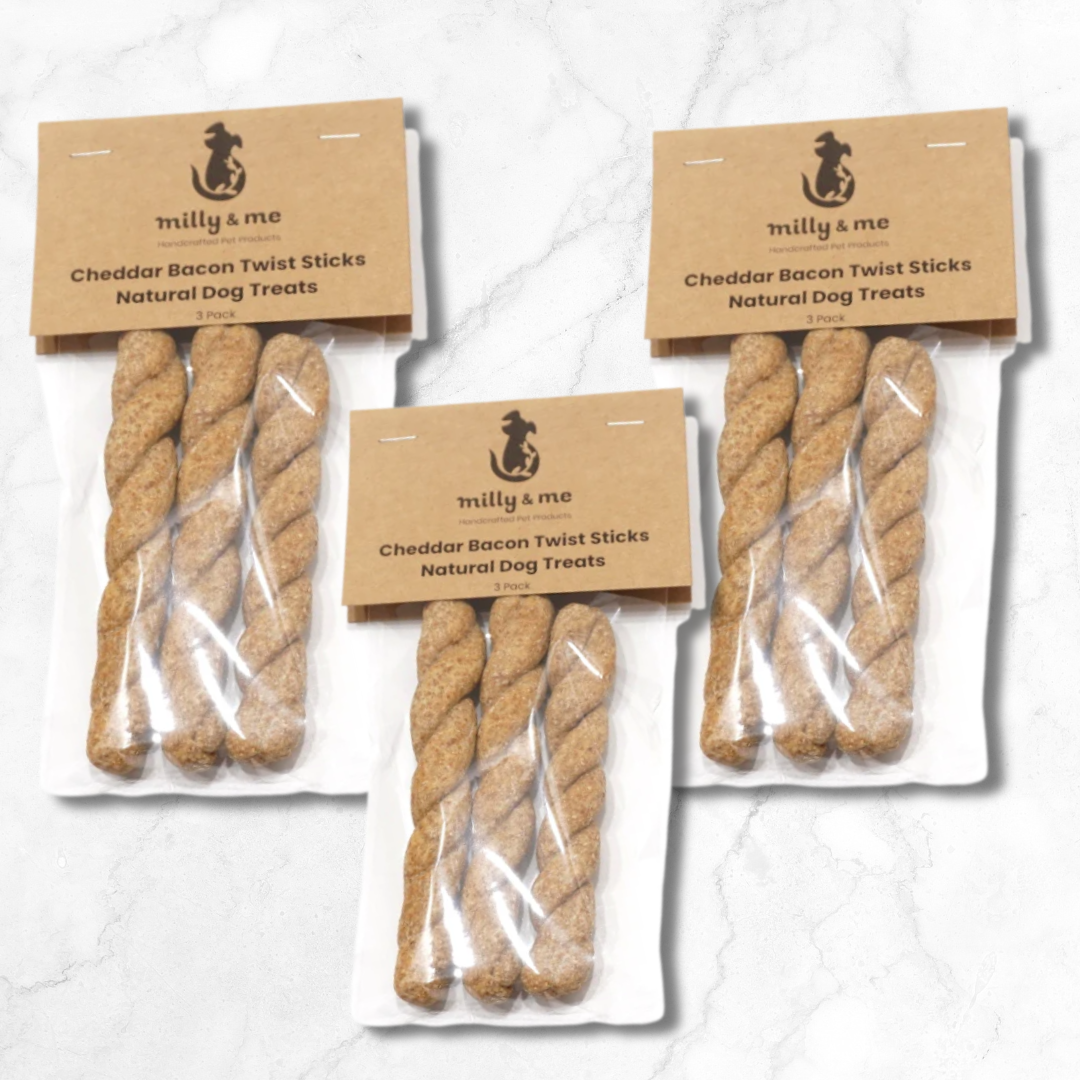 Three packages of Cheddar Bacon Twist Sticks natural dog treats with 'milly & me' branding on a light background.