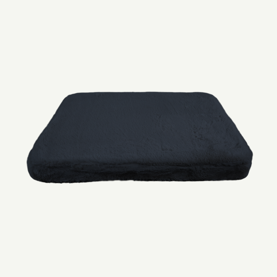 Black faux fur pet bed on a white background