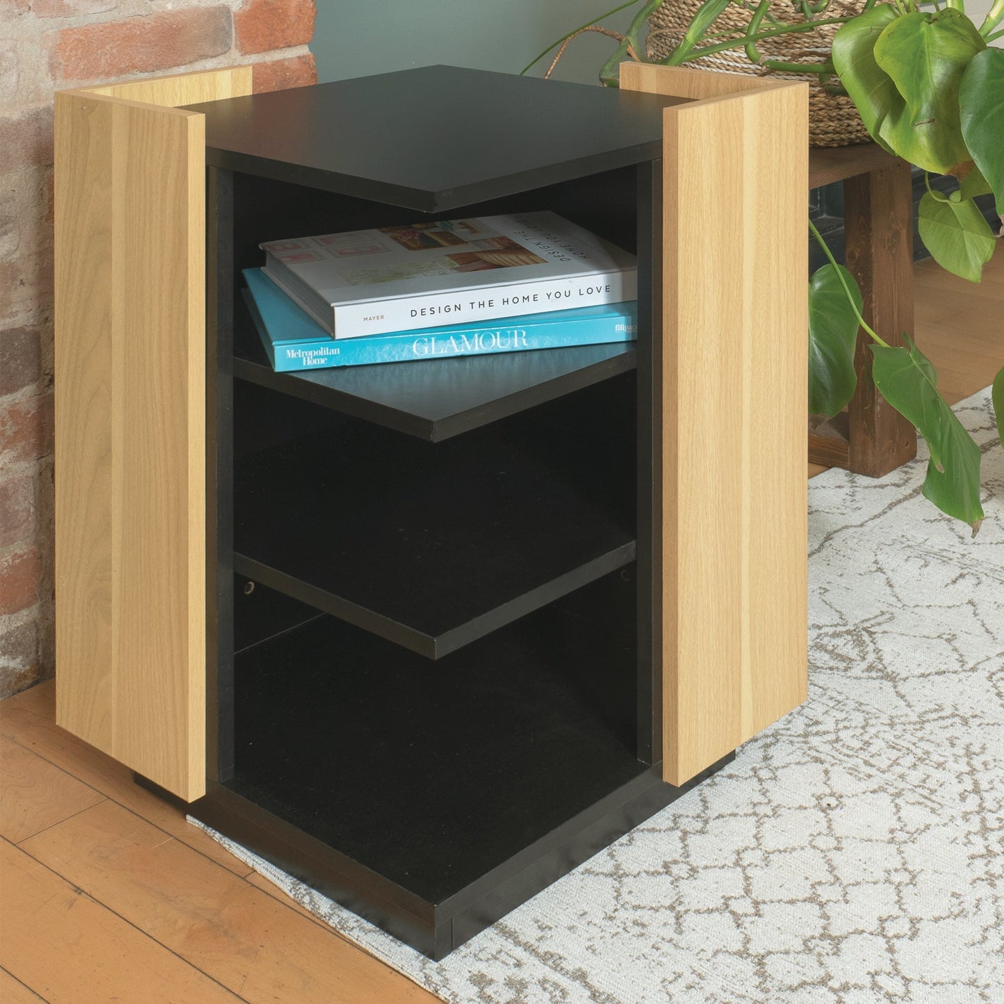 Small bookshelf with books against a brick wall