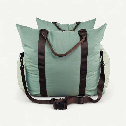 Light blue tote bag with brown straps on a white background