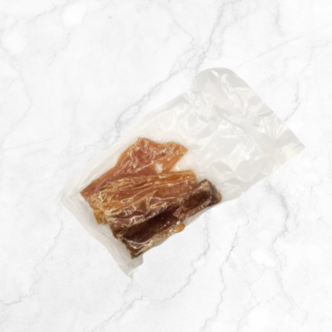 Dried beef tendon pieces in a clear plastic bag on a white textured surface
