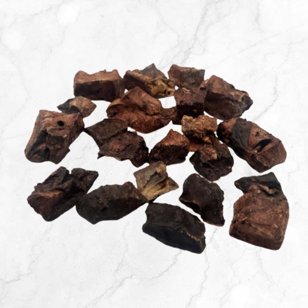 Collection of dried beef liver dog treats on a white textured surface