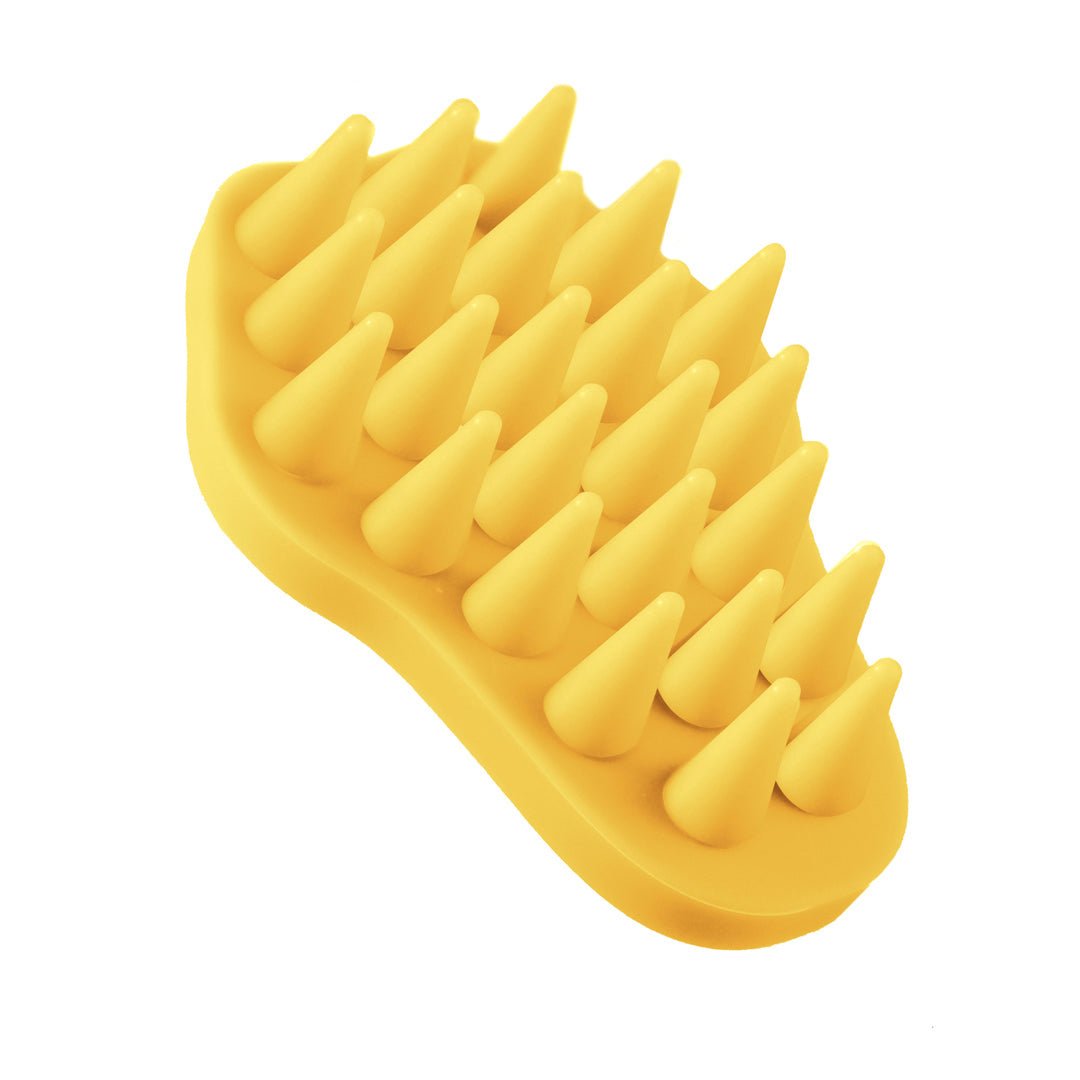 Yellow rubber brush with spike-like bristles on a white background