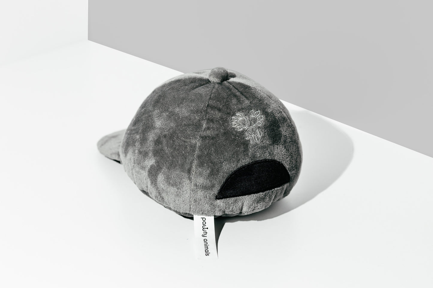 Gray textured cap on a white surface with a gray background
