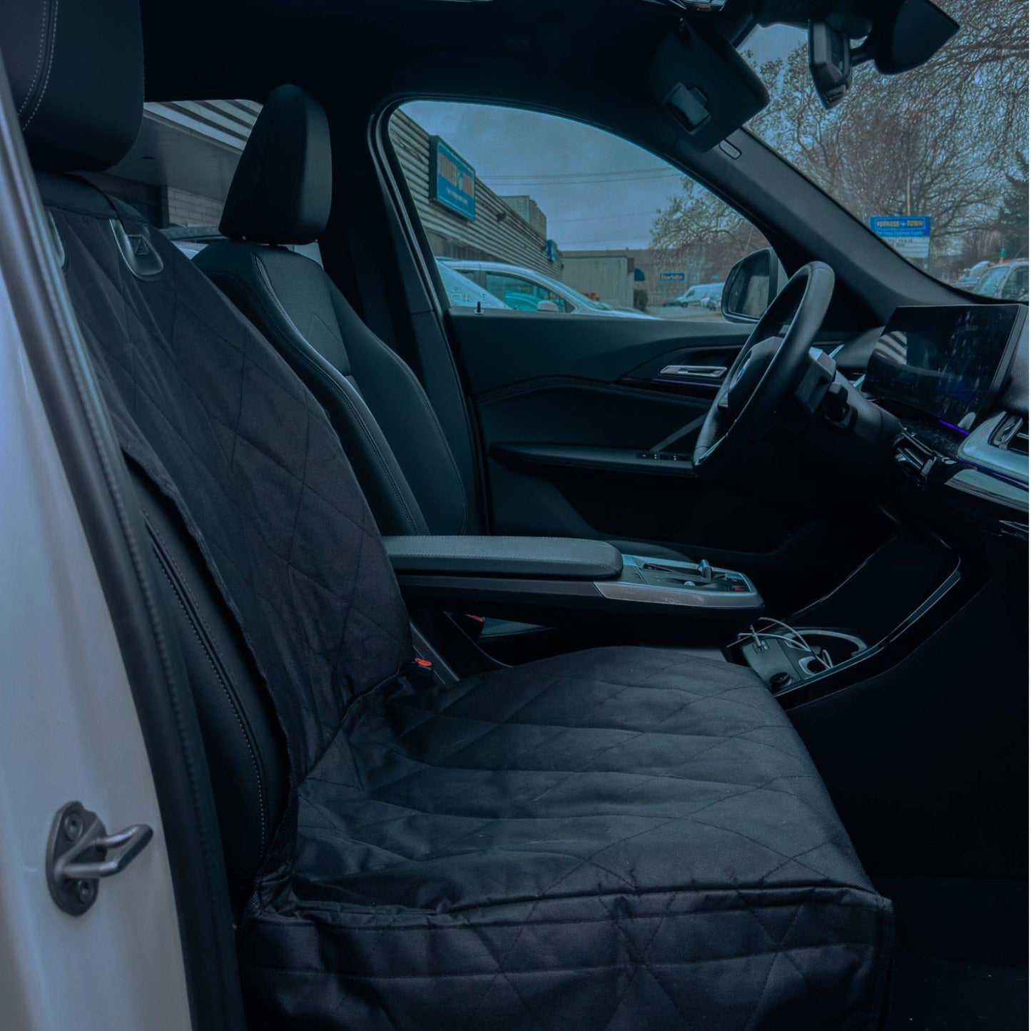 Car interior with a black quilted cover on the seat