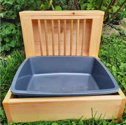 Wooden small pet feeder box with a blue tray on grass