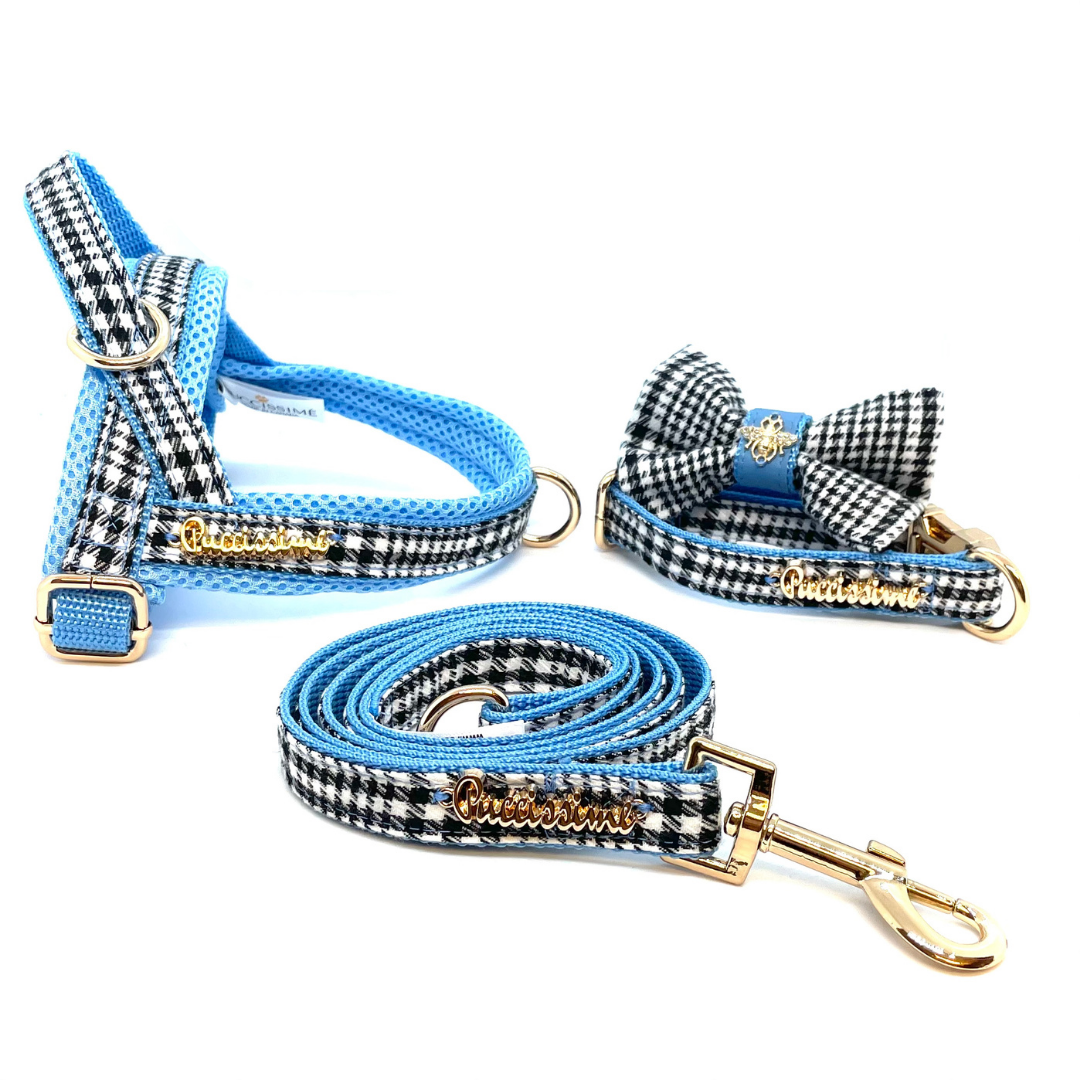 Dog harness, leash, and bow tie set with blue and black checkered pattern on a white background