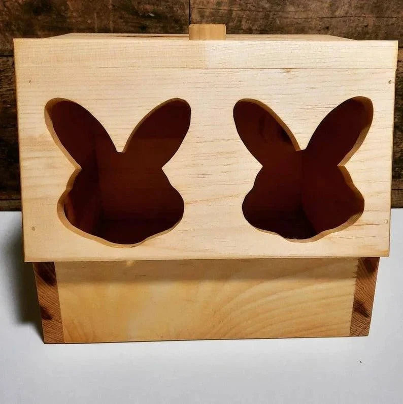 Wooden box with cut-out bunny shapes on a wooden background