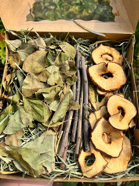 Dried apple mix with dried apple leaves, apple slices, and apple branches in a cardboard box.