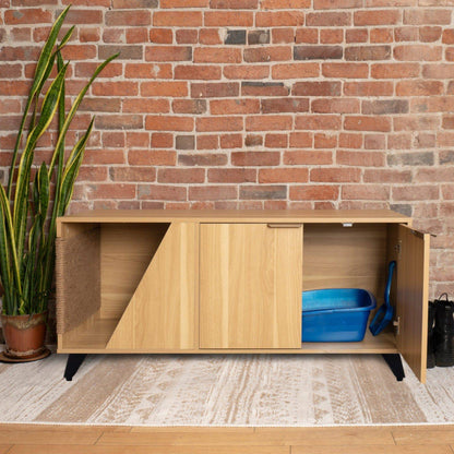 Wooden pet enclosure with a blue litter box and black scoop against a brick wall.