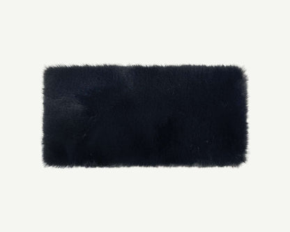 Black rectangular fur rug on a white background