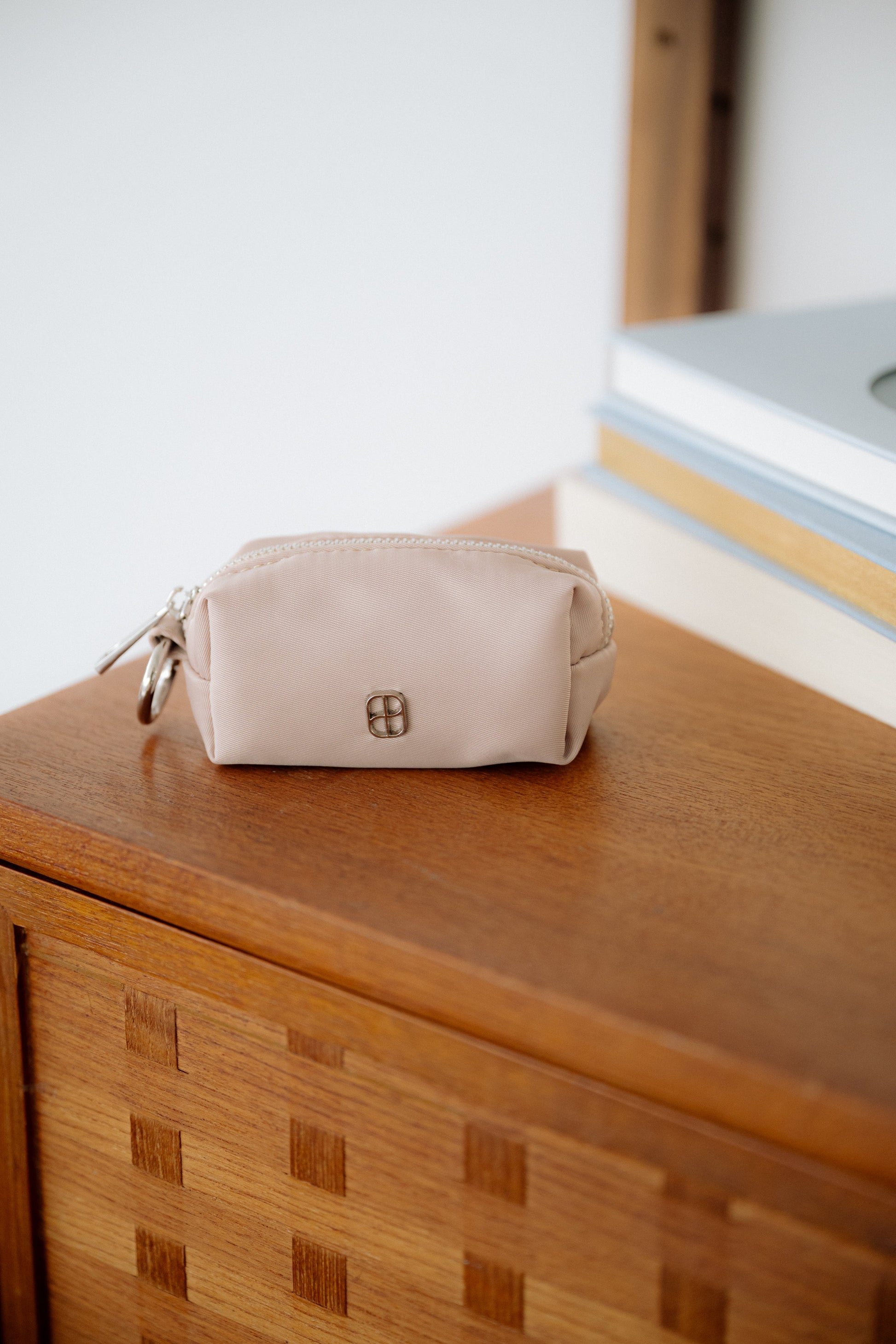 Beige pouch on a wooden surface with a blurred background