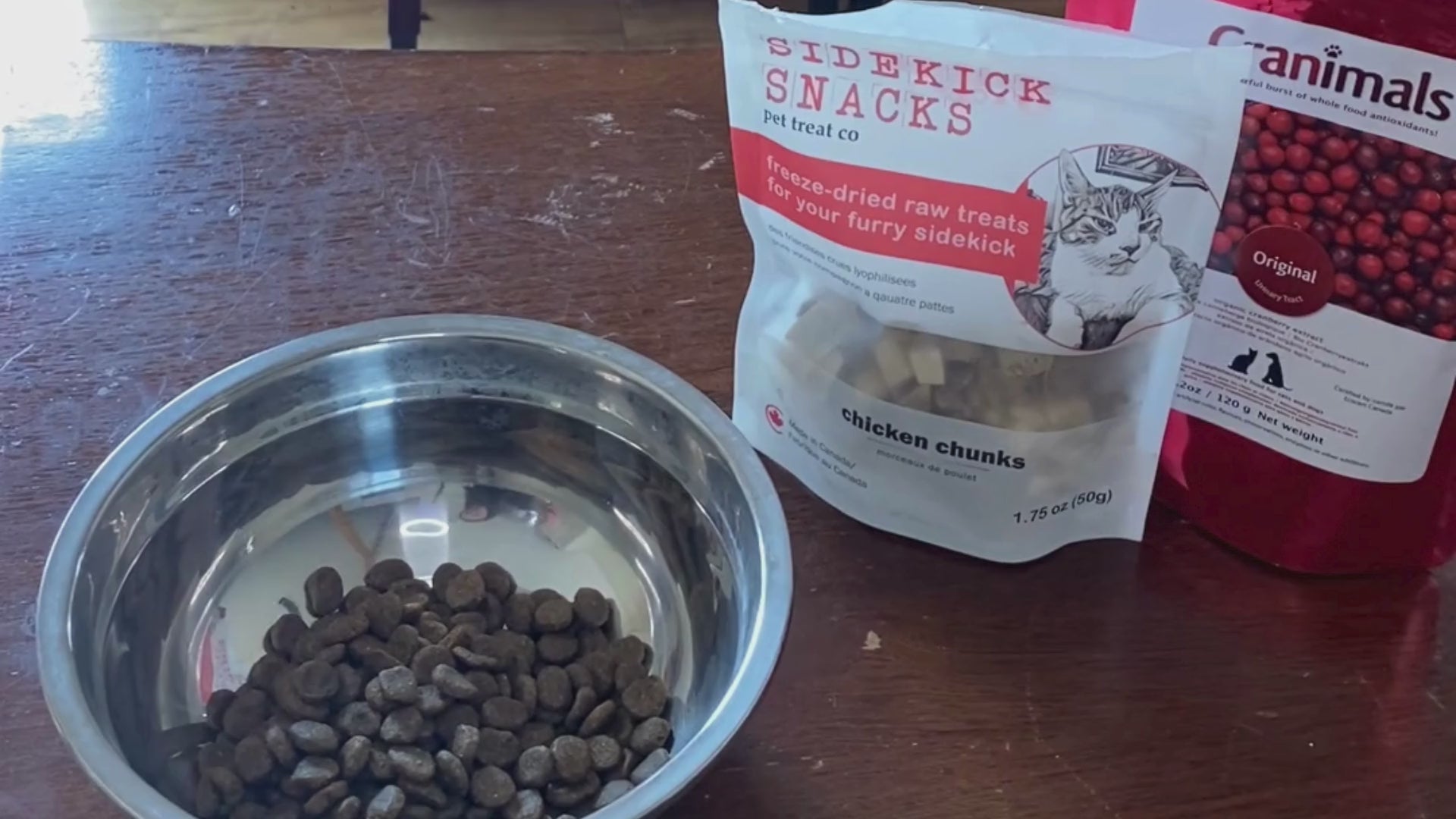 Load video: freeze dried chicken chunks pouring into a bowl of dog food on a kitchen table.